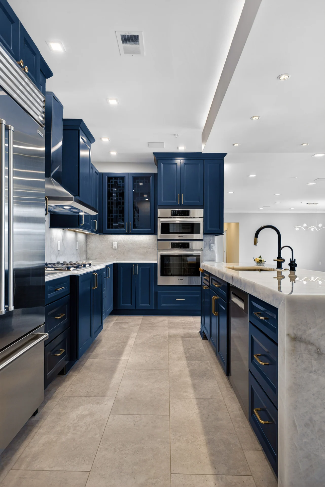 Blue cabinetry and marble island in a photographed kitchen