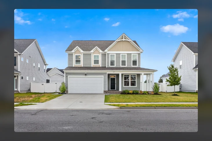 Two-story home with front porch, lawn and attached garage
