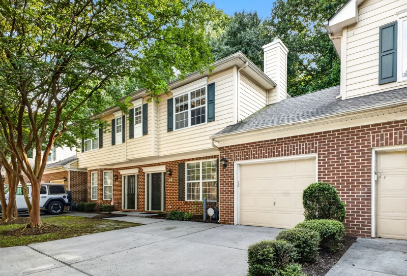 Front exterior of 5877 Echingham Drive with brick, siding and mature trees